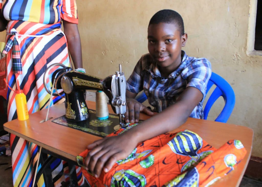 girl learning tailoring on a sewing machine teda - Teso Elites Development Association