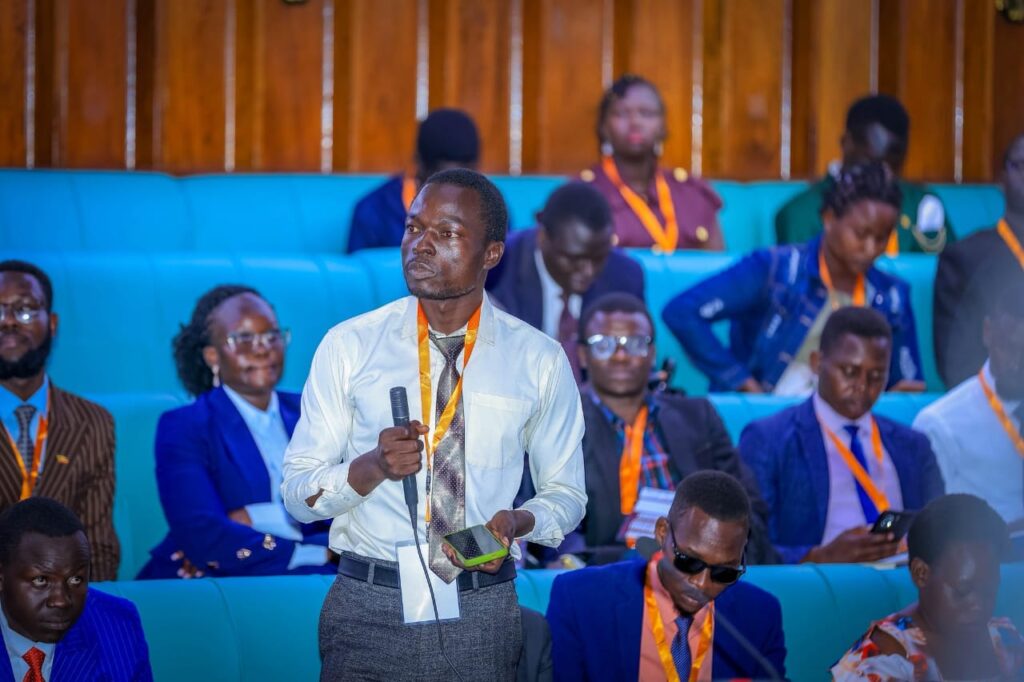 youth delegate speaking with microphone in parliament teda - Teso Elites Development Association